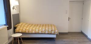 a small room with a bed and a stool at Gîte De La Verdurette in Pettonville
