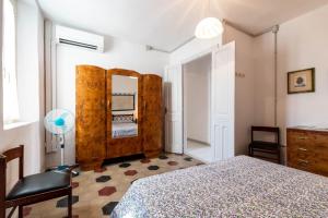 a bedroom with a bed and a mirror at Casa Damiano 1935 in Villasimius
