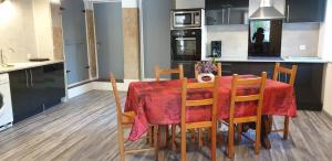 a kitchen with a table with a red table cloth at Gîte De La Verdurette in Pettonville +5 photos