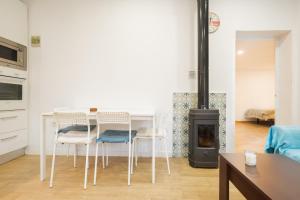 a living room with a table and chairs and a stove at Casa Familiar con Piscina in La Rinconada