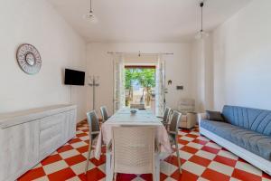 a dining room with a table and a couch at Villa Cinzia in Torre Lapillo