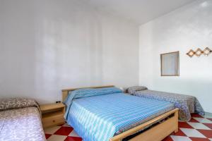 a bedroom with two beds and a checkered floor at Villa Cinzia in Torre Lapillo