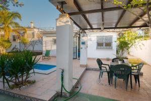 a patio with a table and chairs and a house at Casa Familiar con Piscina in La Rinconada