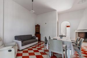 a living room with a couch and a table and chairs at Villa Cinzia in Torre Lapillo