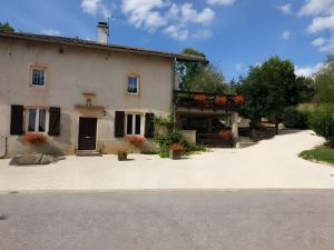 a white building with flowers in front of it at Gîte De La Verdurette in Pettonville
