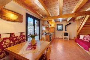 a kitchen and living room with a wooden ceiling at La Maison de Marguerite in Saint Vincent