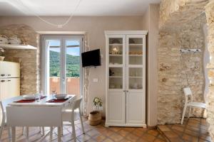 a kitchen with a white table and white chairs at Casa Virginia - Vigna in Orco Feglino