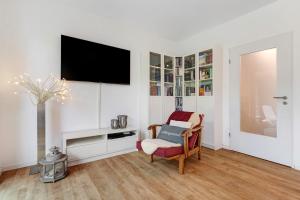 a living room with a tv on a white wall at Haus 15 in Offenburg