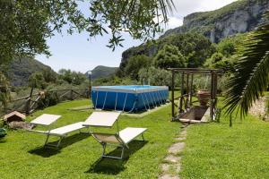 a group of chairs and a picnic table in the grass at Casa Virginia - Vigna in Orco Feglino