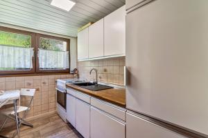 a kitchen with a refrigerator and a table in it at Heidi Kimmig in Bad Griesbach