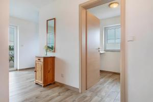 an empty room with a mirror and a wooden dresser at Waldsuite in Friedrichshafen +27 photos