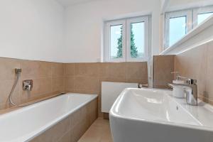 a bathroom with a white tub and a sink at Haus 15 in Offenburg +28 photos