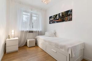 a white bedroom with a bed and a window at Haus 15 in Offenburg