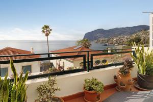 a balcony with potted plants and a view of the ocean at Luzias Apartment in Funchal
