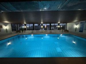 a large swimming pool with lights in a building at Über den Wolken in Höchenschwand