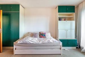 a bedroom with green cabinets and a white bed at Über den Wolken in Höchenschwand +10 photos