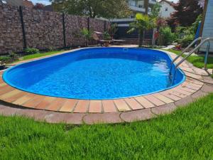 a large blue pool with a wooden deck around it at Ferienwohnung Rimbach in Rimbach