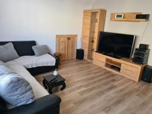 a living room with a couch and a flat screen tv at Ferienwohnung Rimbach in Rimbach