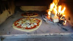 two pizzas are cooking in a brick oven at Drei Zinnen in Hiltpoltstein +17 photos