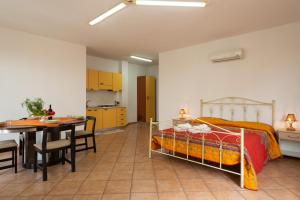 a bedroom with a bed and a table and a kitchen at Monolocale nel centro di Racale in Racale