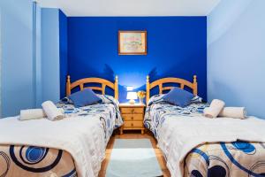 two beds in a room with blue walls at Casa Lino in Culla