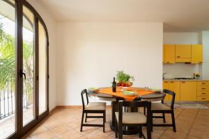 a kitchen and dining room with a wooden table and chairs at Monolocale nel centro di Racale in Racale +7 photos