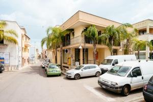 a street with cars parked in front of a building at Monolocale nel centro di Racale in Racale