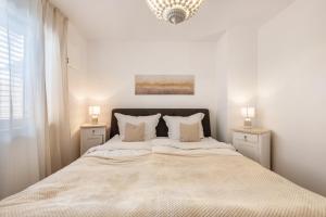 a white bedroom with a large bed with two night stands at bei Thérèse - Erdgeschoss in Miltach