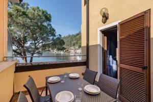 a table on a balcony with a view of the water at Casabb in Toscolano Maderno