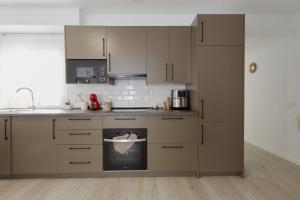 a kitchen with white cabinets and an oven at Casa Pablo City Center in Fuengirola +8 photos