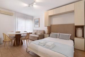 a bedroom with a bed and a living room at Almadrava House in Tavira +14 photos