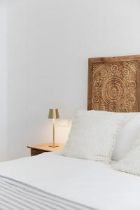 a white bed with a wooden headboard and a table at Casa Pablo City Center in Fuengirola