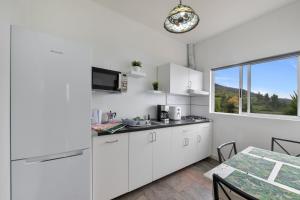 a kitchen with white cabinets and a table and a window at Vv Terrazita in Tijarafe