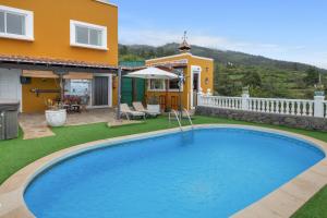 a swimming pool in a yard next to a house at Vv Terrazita in Tijarafe