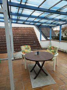 a wooden table and two chairs on a patio at Ferienunterkunft Göhlich in Maintal