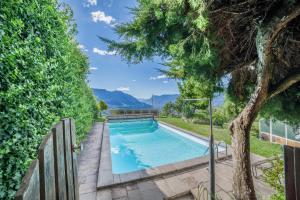 a swimming pool in a yard with a tree at Apartment Belvedere in Caines