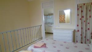 a bedroom with a crib and a dresser and a mirror at Playa de las Americas Cool Duplex in Playa de las Americas +31 photos