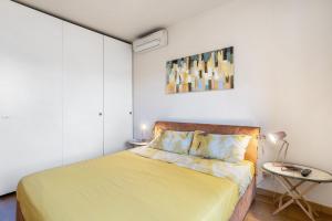 a bedroom with a yellow bed and a table at Crocetta10 in Milan