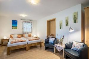 a bedroom with a bed and a couch and chairs at Ferienwohnung Ohnemus in Schuttertal