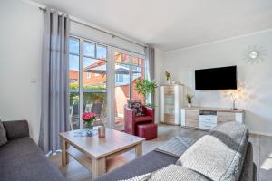 a living room with a couch and a tv at Haus Windflüchter 3b in Zingst