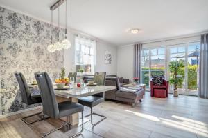 a dining room and living room with a table and chairs at Haus Windflüchter 3b in Zingst
