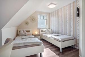 a bedroom with two beds and a window at Haus Windflüchter 3b in Zingst