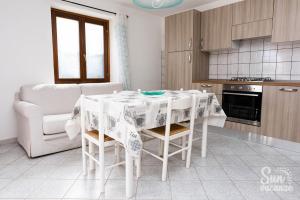 a kitchen with a table with a white table cloth at Malamuri 5 sun vacanze in Budoni +5 photos