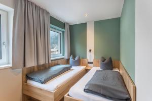 two beds in a room with a window at Luisalle Top 3 in Auffach