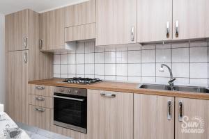 a kitchen with wooden cabinets and a sink at Malamuri 5 sun vacanze in Budoni