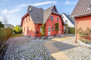 a house with a cobblestone street in front at Haus Windflüchter 3b in Zingst