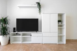 a white entertainment unit with a television on it at Center Beach Calafell in Calafell