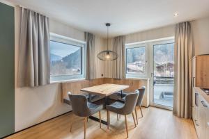 a dining room with a table and chairs and windows at Luisalle Top 3 in Auffach