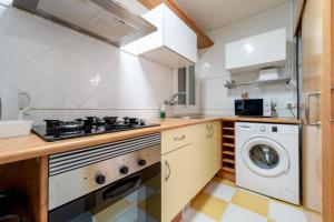 a kitchen with a stove and a washer and dryer at Center Beach Calafell in Calafell