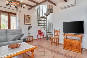 a living room with a couch and a tv at Casa Torre del Manzano in Torrox